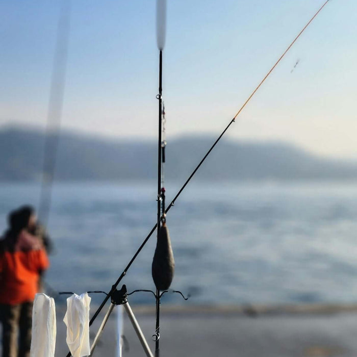 Fishing Made Simple with Bait Mesh Unslung Mono 0.35mm - fishing rods by the water's edge.