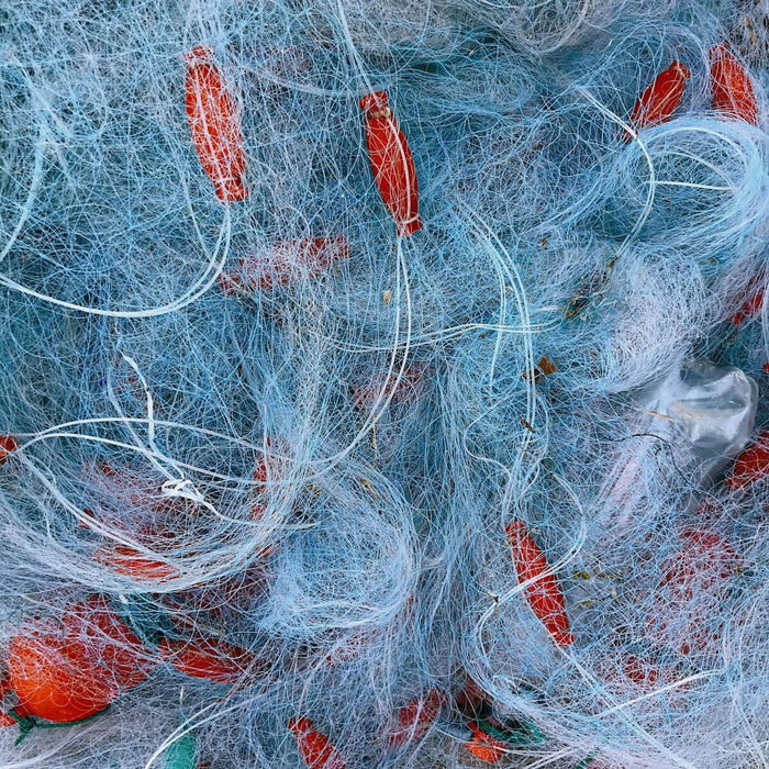 Heavy Duty Pacific Island Nets tangled in blue and red fishing net materials.