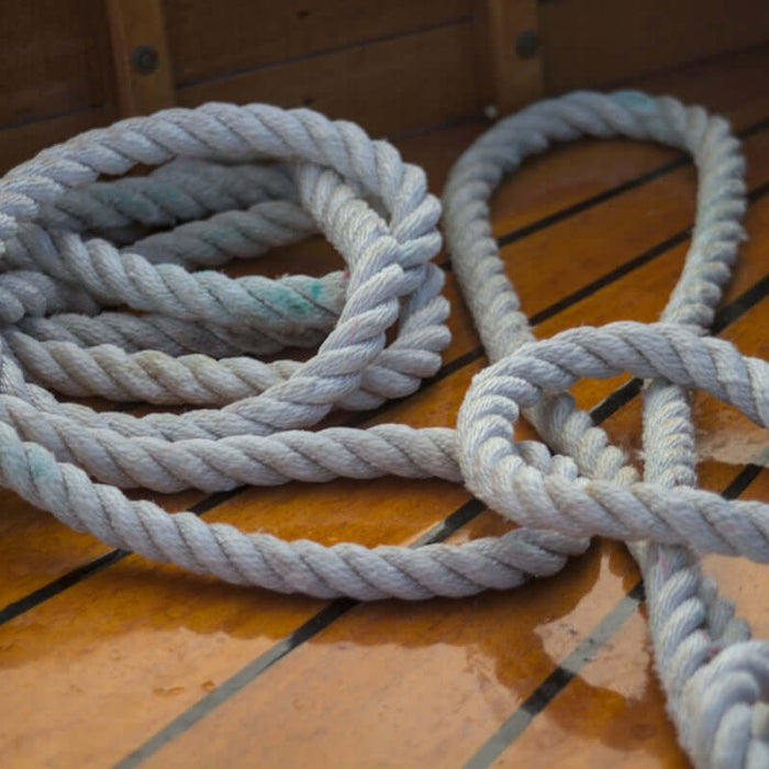 Coiled rope rests on a wooden deck.