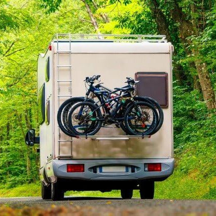 RV Marine Gear featuring a recreational vehicle with bikes attached, ideal for outdoor adventures in New Zealand.