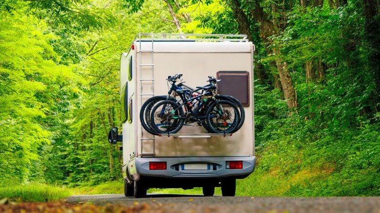 RV Marine Gear featuring a recreational vehicle with bikes attached, ideal for outdoor adventures in New Zealand.