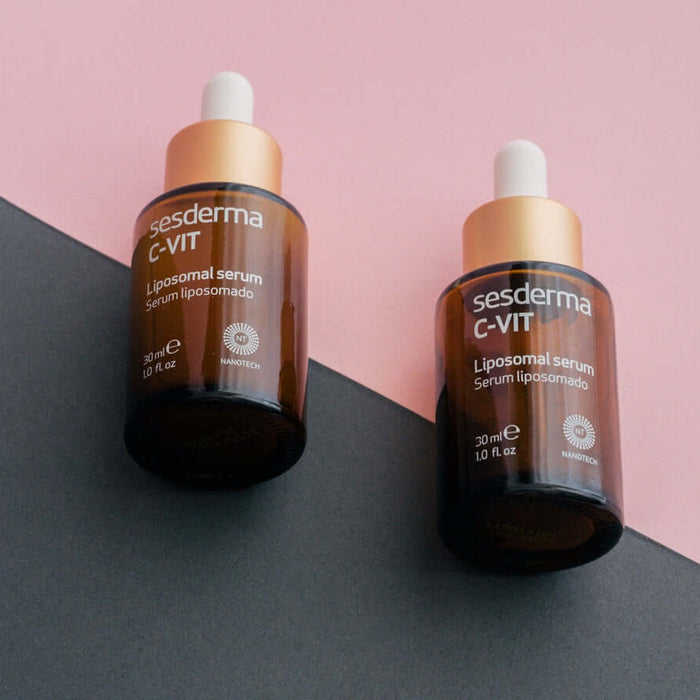 two bottles of gerania vitamin c - lift on a pink and black background