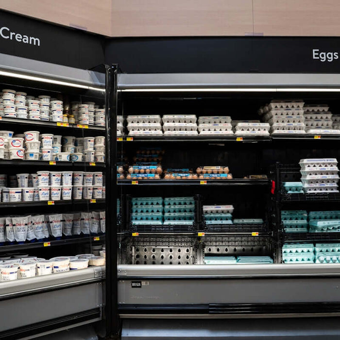 Sour cream and eggs displayed in a grocery store refrigerator section.