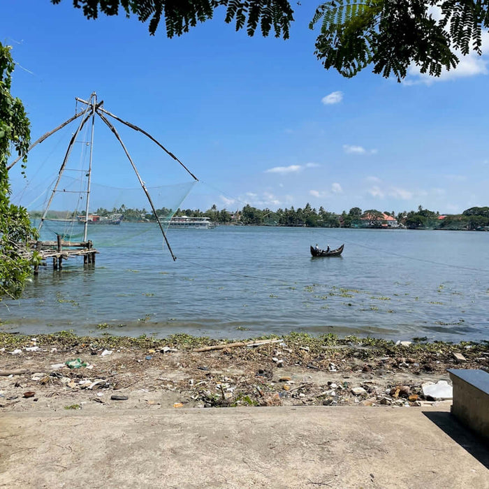 The 60m Net Buoy Anchor Combo 2kg Danforth at a scenic waterfront with a fishing boat.