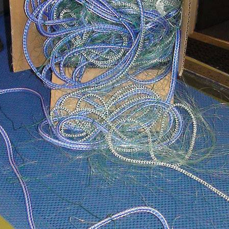 A Guide to South Island Flounder Set Nets 20m to 60m showing tangled fishing nets and gear on a table.