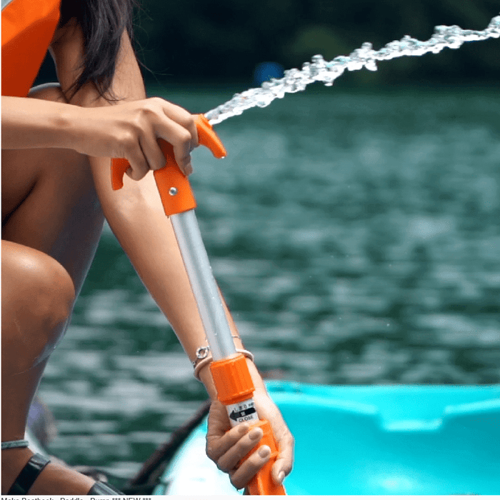 BACK IN STOCK Maka Baasthook Paddle Pump used on kayak with water spraying out.