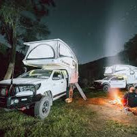 Two RVs parked at night near a campfire, symbolizing RV & Marine Supplies Every Kiwi Traveller Needs.