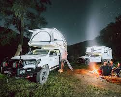 Two RVs parked at night near a campfire, symbolizing RV & Marine Supplies Every Kiwi Traveller Needs.