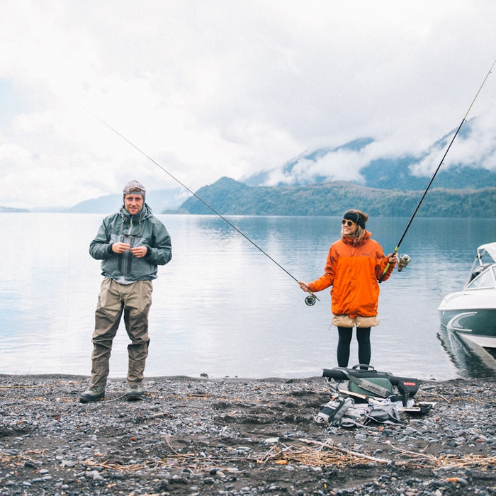 man in blue jacket and gray pants fishing on sea during daytime
