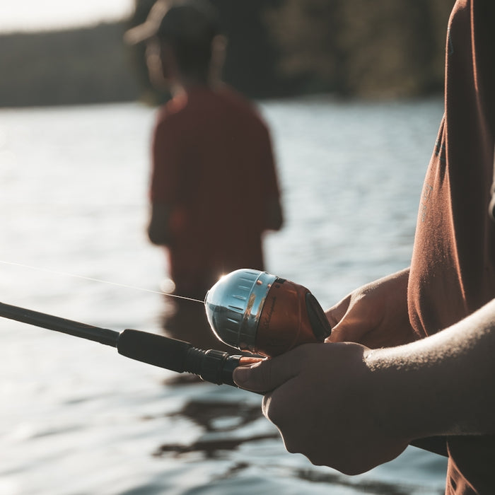 woman holding black and silver fishing rod