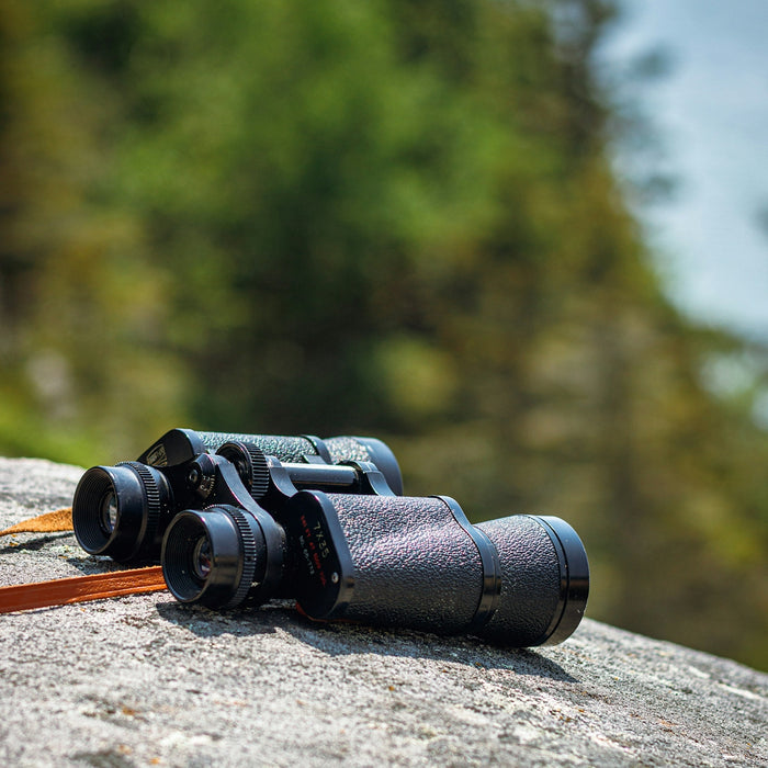 a pair of binoculars sitting on top of a rock