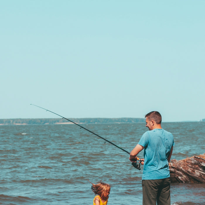 a man and a child fishing in the ocean