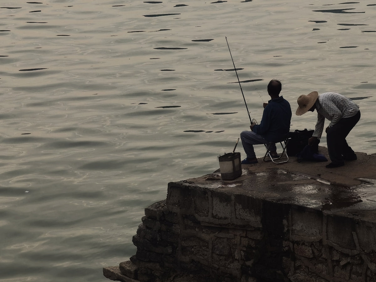 a man and a woman fishing on a pier