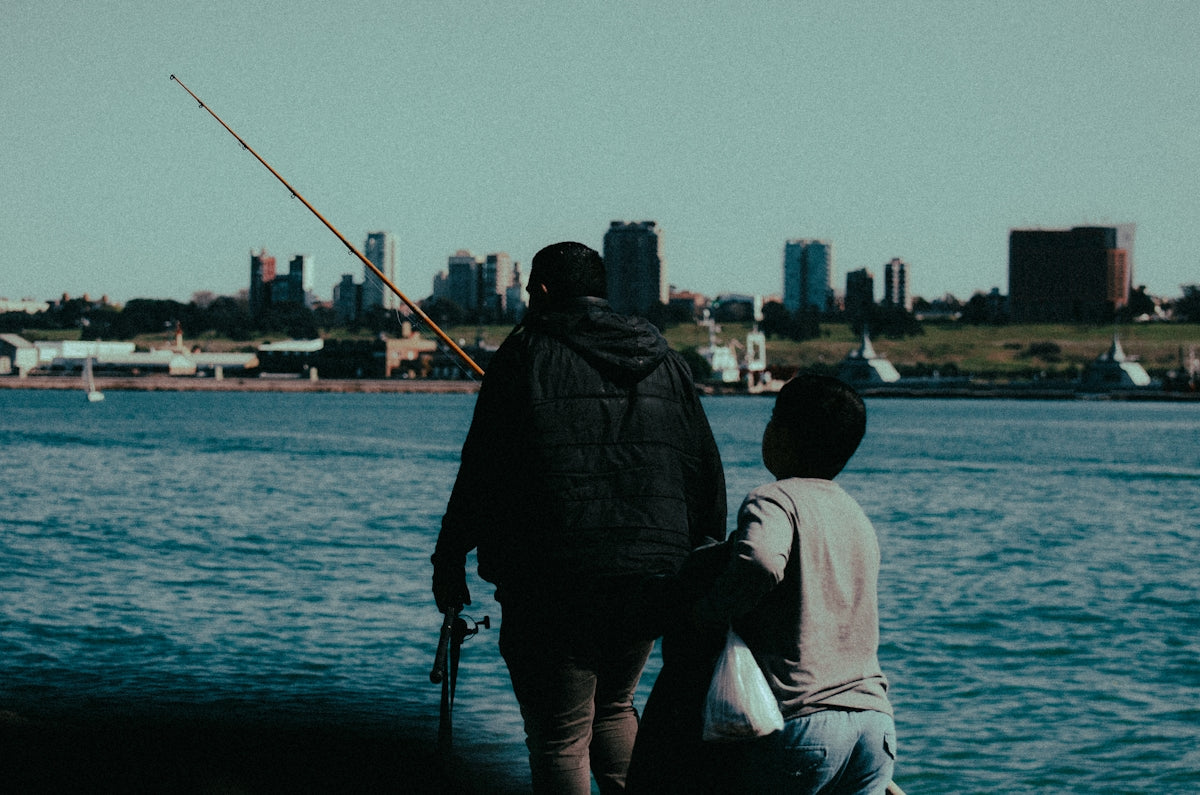 A man and a boy fishing on a lake