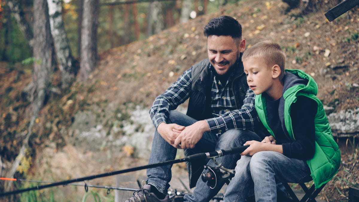 Father and son are fishing together.