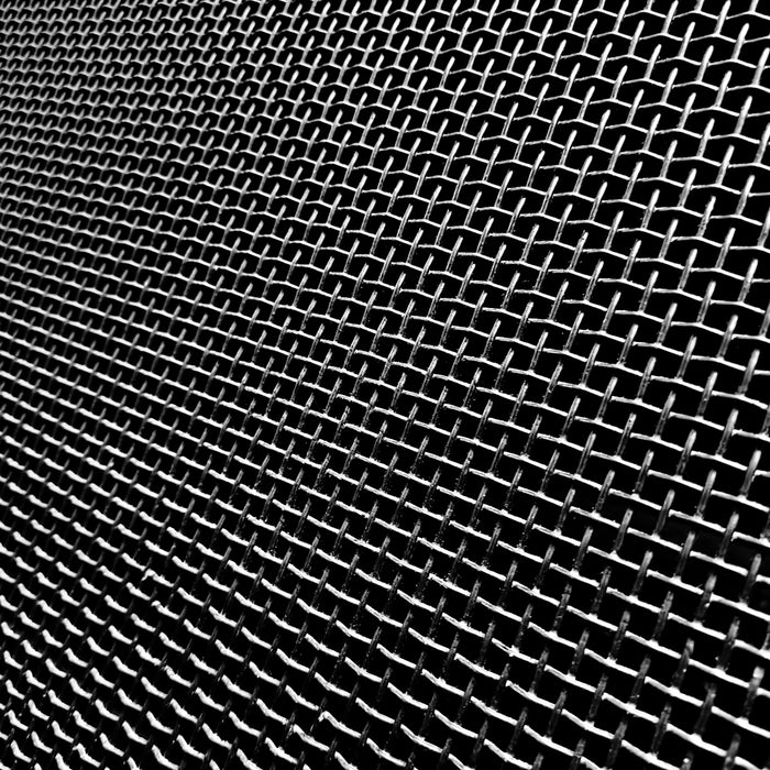 Close-up of a metal mesh screen with a dark background