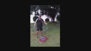 Frisbee Style 6FT x 1-00 Inch AM Style Cast Net demonstration by angler in grassy area.